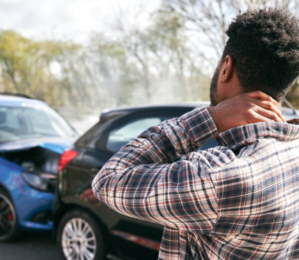 man holding neck after suffering a car accident
