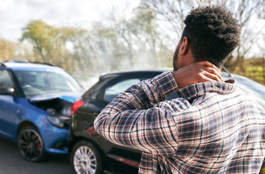 man holding neck after suffering a car accident